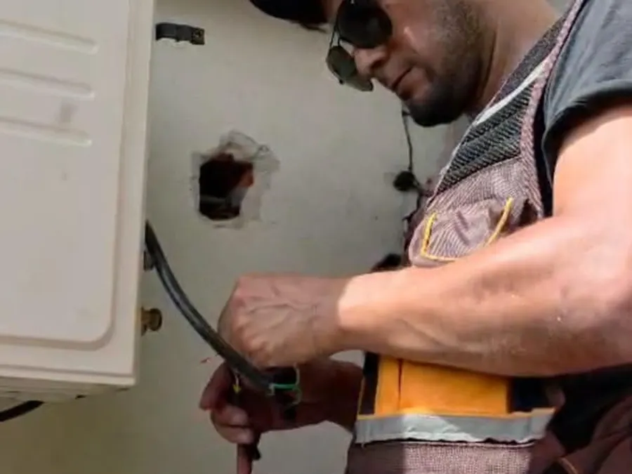 Técnico de 24° Clima conectando la unidad exterior de un aire acondicionado